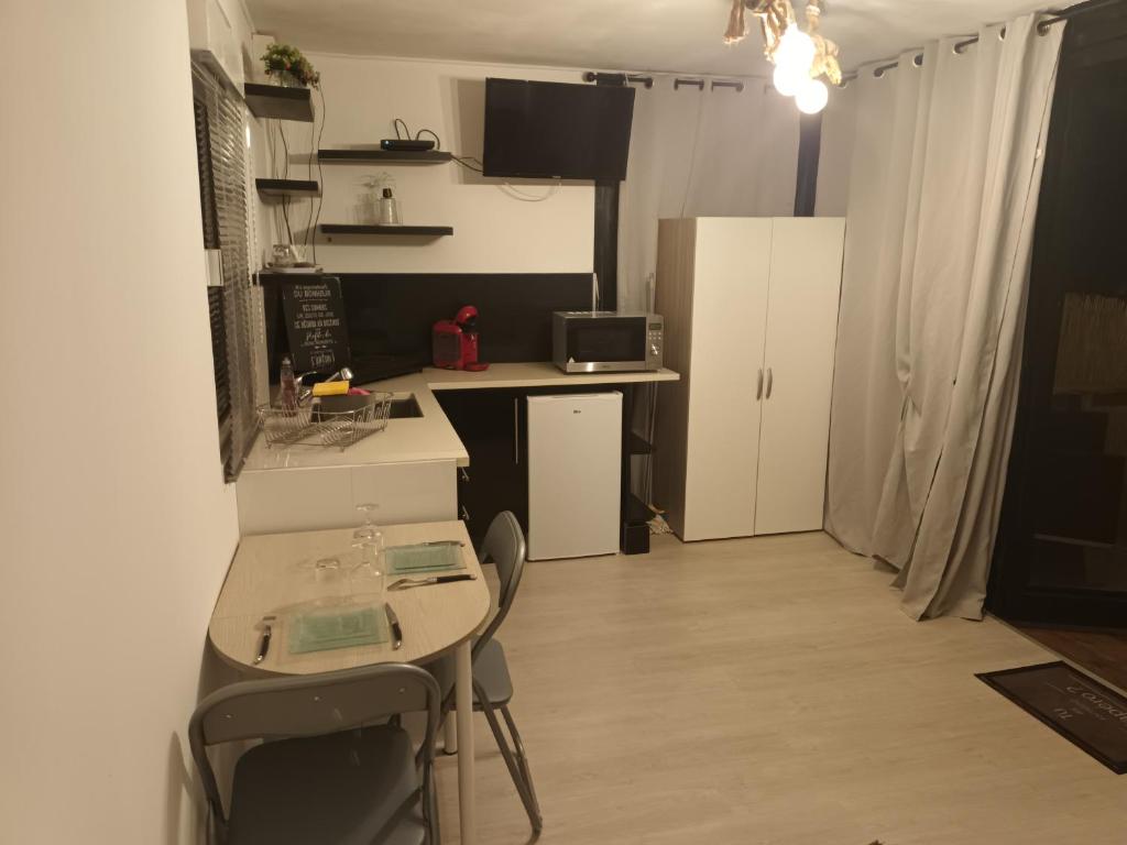 małą kuchnię ze stołem i krzesłami w pokoju w obiekcie U San Francescu Maisonette Modulaire Type studio w mieście Volpajola