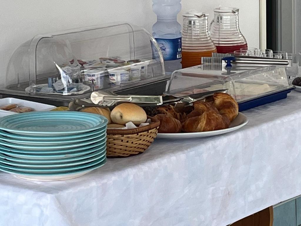 a table with plates and baskets of food on it at Miriasol Bed and Breakfast in Capo Vaticano