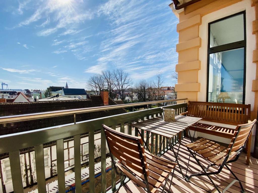 2 Stühle und ein Tisch auf dem Balkon in der Unterkunft Berringer, Krabbe, direkt an der Promenade in Warnemünde