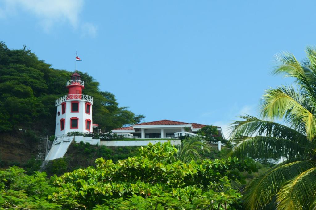 un faro al lado de una colina con árboles en The Lighthouse Ocotal, en Coco