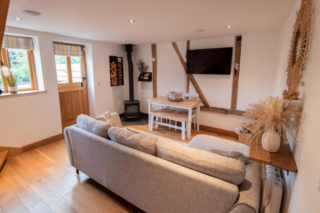 a living room with a couch and a table at Bramble Cottage - Cosy 2 Bed With Deluxe HOT TUB & Log Burner in Hereford