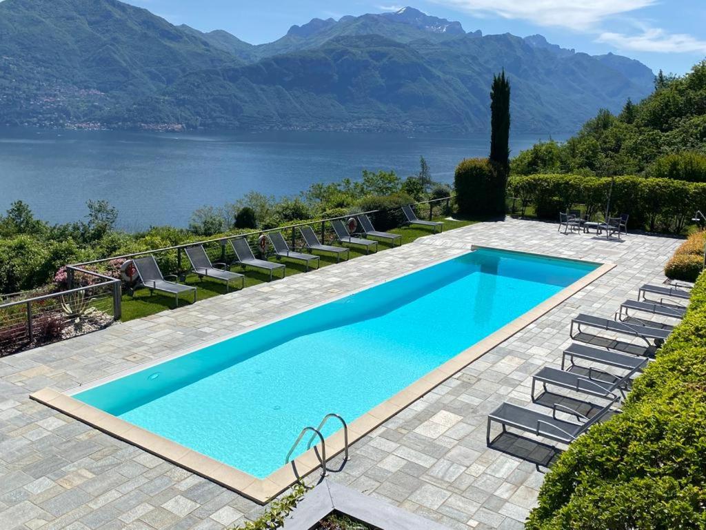 a swimming pool with chairs and a view of a lake at Residenza Parco Sant Andrea in Menaggio