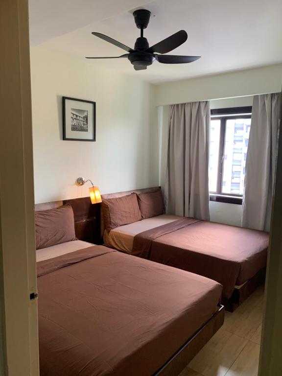a bedroom with two beds and a ceiling fan at Afamosa Dsavoy Condotel in Kampong Alor Gajah
