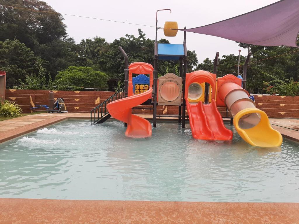 una piscina con un tobogán de agua en un patio trasero en RedDoorz @ Lazarian Hotel and Resort Cagayan Valley, 