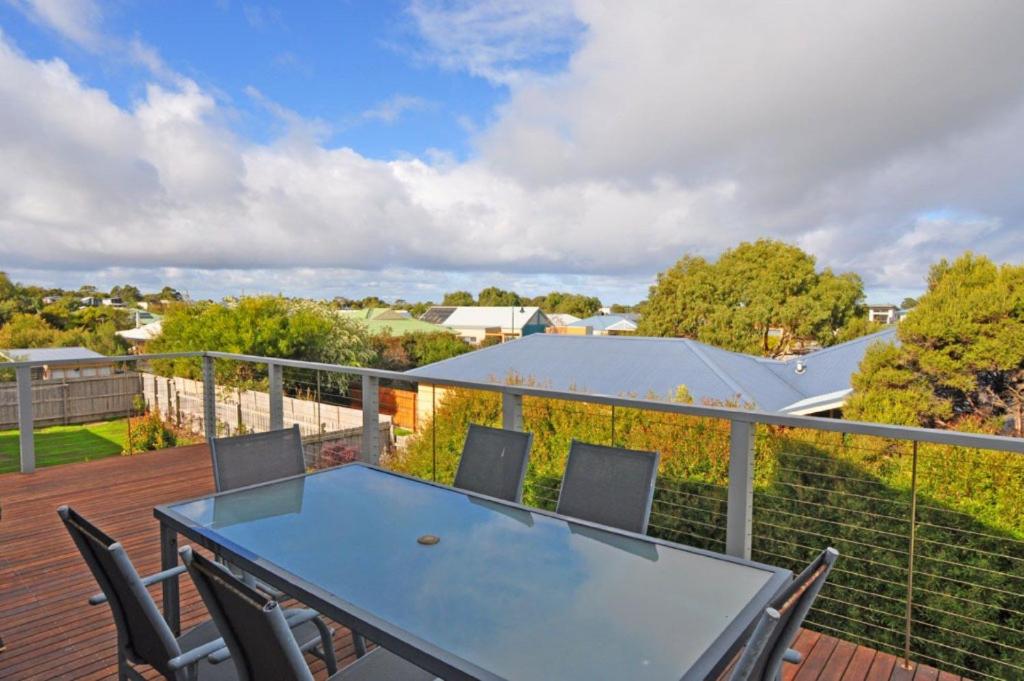 a patio with a table and chairs on a deck at Chiaro Villa - Surf Side in Inverloch