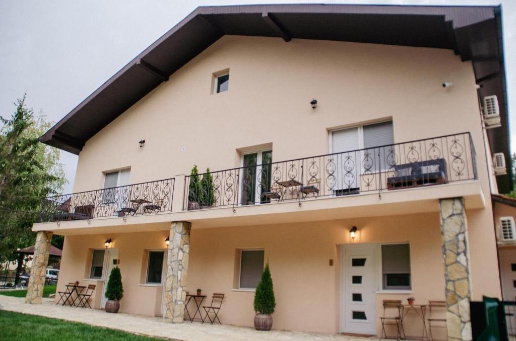 a building with a balcony with tables and chairs at Central park in Vrdnik