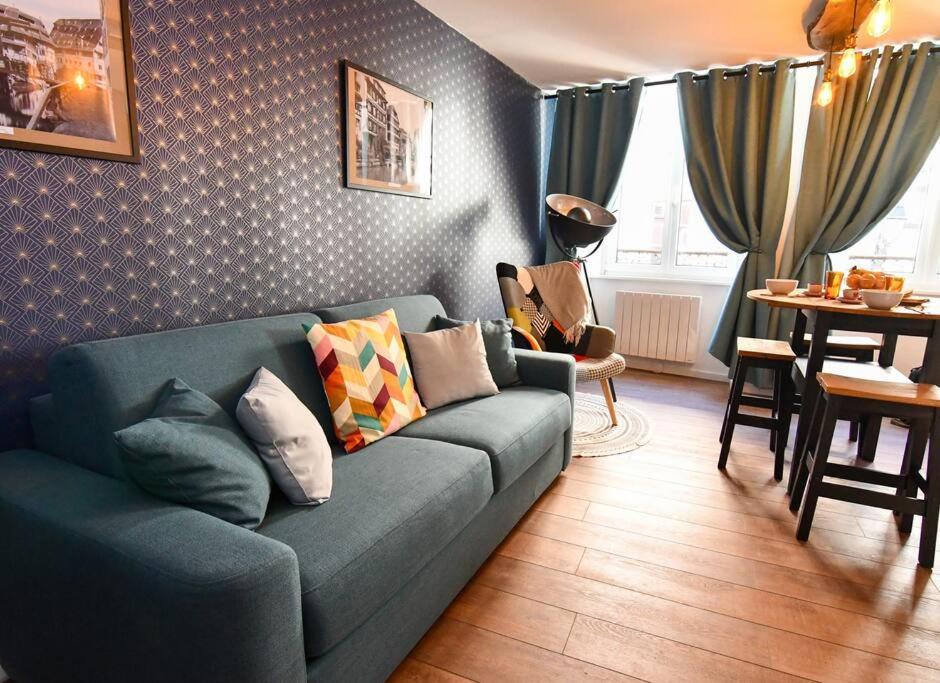 sala de estar con sofá azul y mesa en Au Fil du Temps, en Sélestat