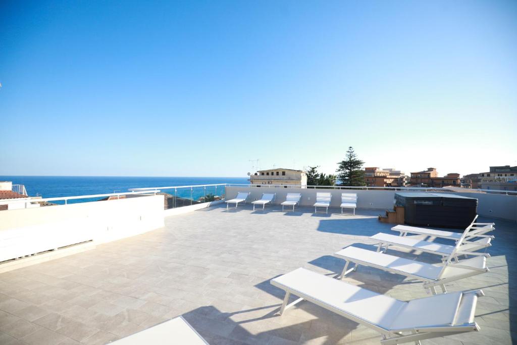 a group of white lounge chairs on a roof at Solmaris Tropea Rooms & Suites in Tropea