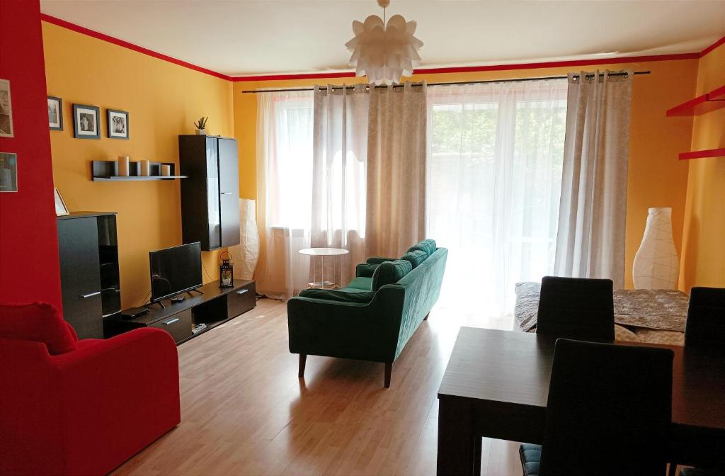 ポズナンにあるDarna Apartamenty Avena 1のリビングルーム(ソファ、椅子、テレビ付)