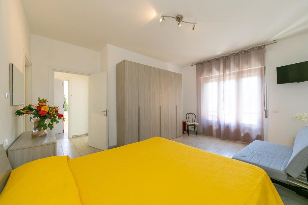 - une chambre avec un lit jaune et un canapé dans l'établissement Casa Etruria, à Marina di Castagneto Carducci