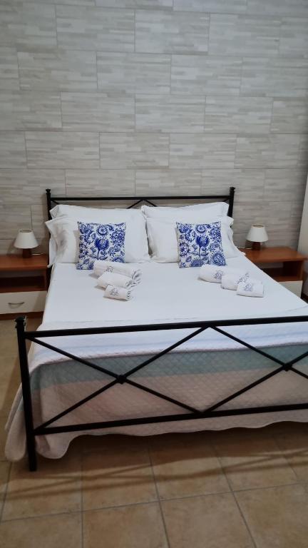a bed with white sheets and blue and white pillows at Soluzionestate in Ispica