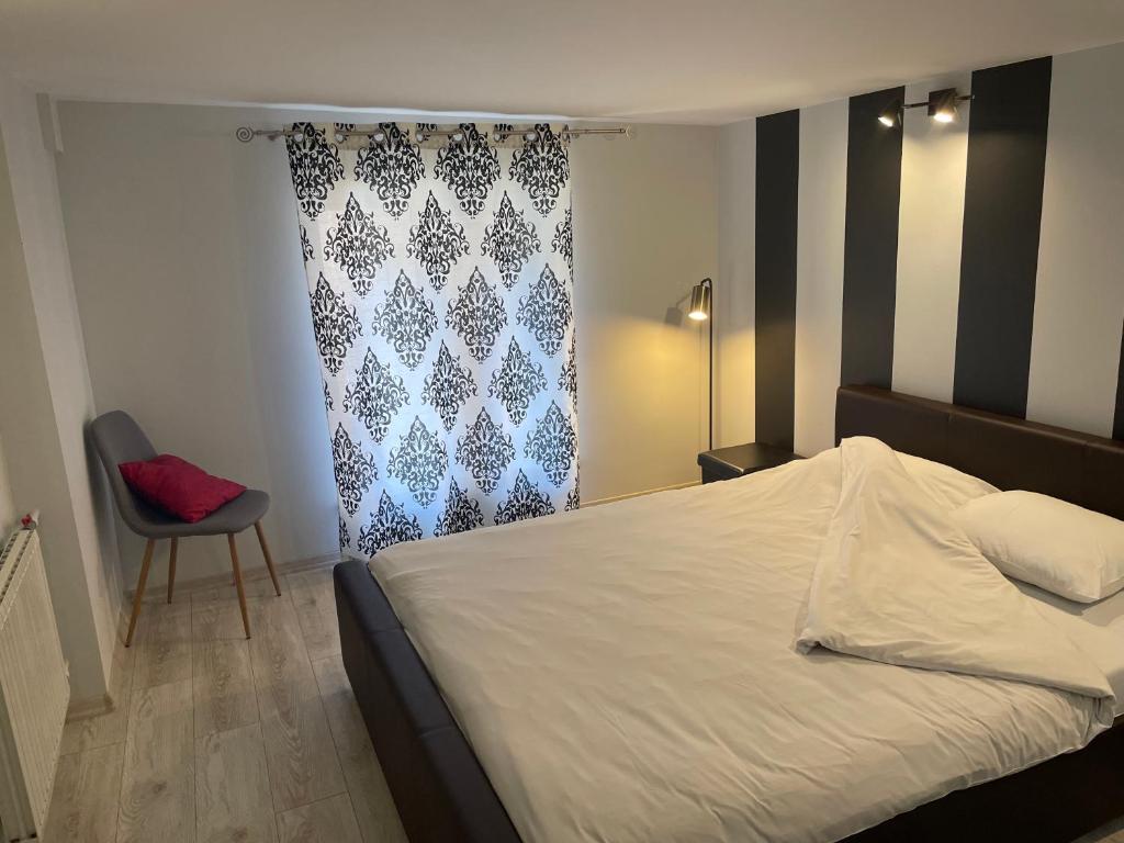 una camera con un letto bianco e una sedia di Modern-style flat 2 a Riga