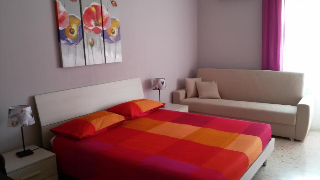 ローマにあるIsabella Roomsのベッドルーム(カラフルなベッド1台、ソファ付)