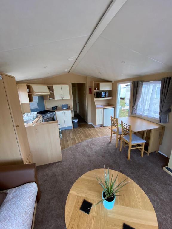 a living room with a table and a kitchen at 1 Martello Beach 8 berth holiday home with pools in Clacton-on-Sea