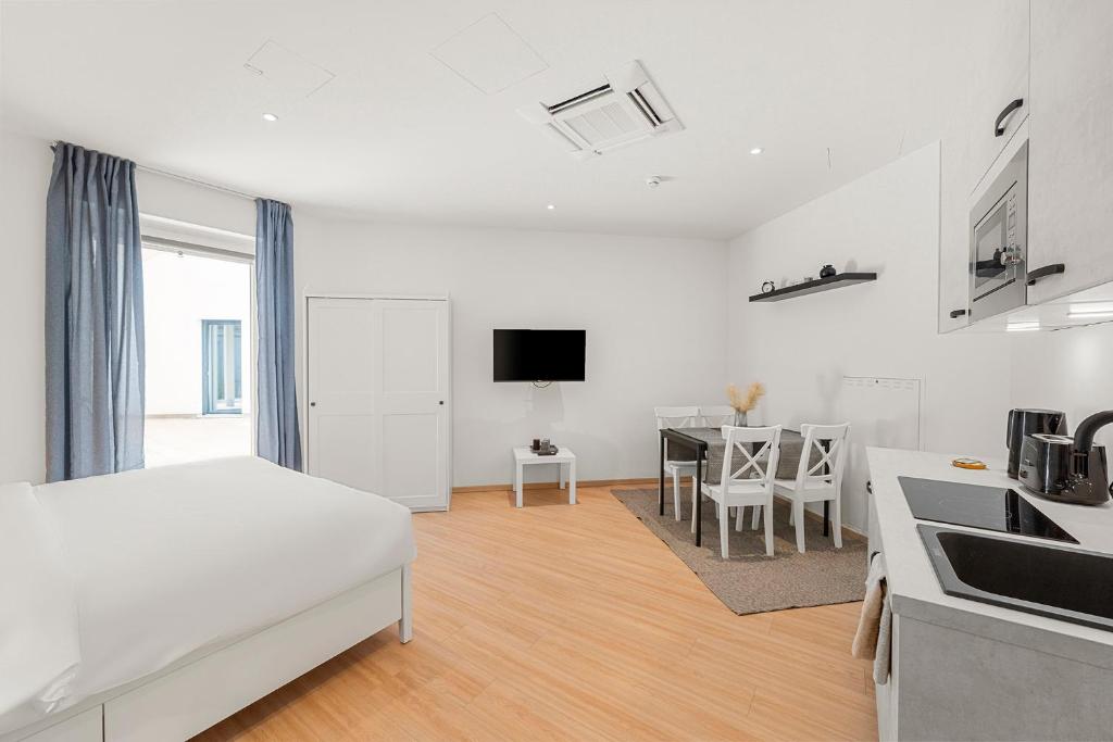 a white room with a bed and a kitchen at Boutique Space VIE #4o1 in Vienna