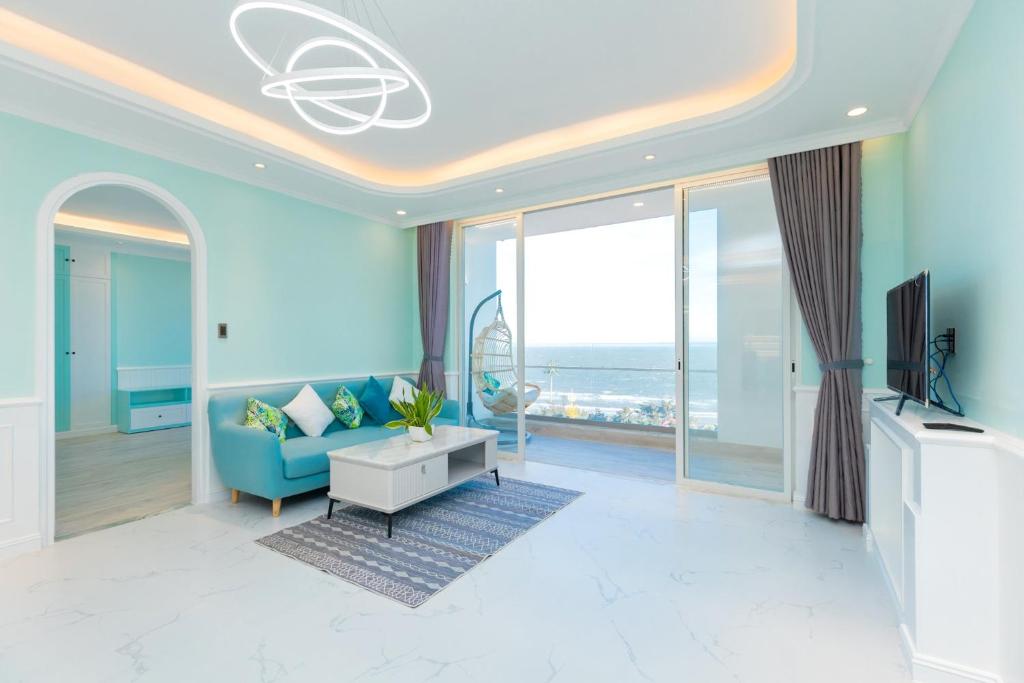 a living room with a blue couch and a tv at Căn Hộ View Biển Santorini, Vũng Tàu in Vung Tau