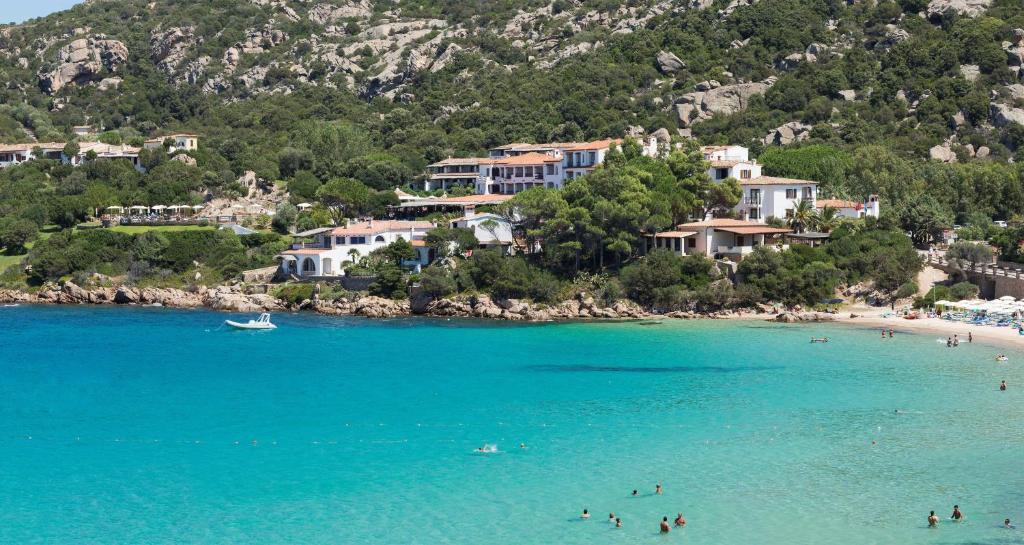 un groupe de personnes sur une plage dans l'eau dans l'établissement Hotel La Bisaccia, à Baja Sardinia