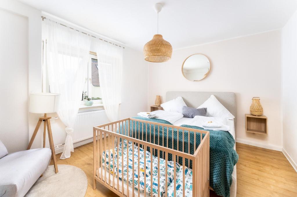 a white bedroom with a crib in a room at Stay Awesome - Familien-Apartment am Botanischen Garten Kassel in Kassel
