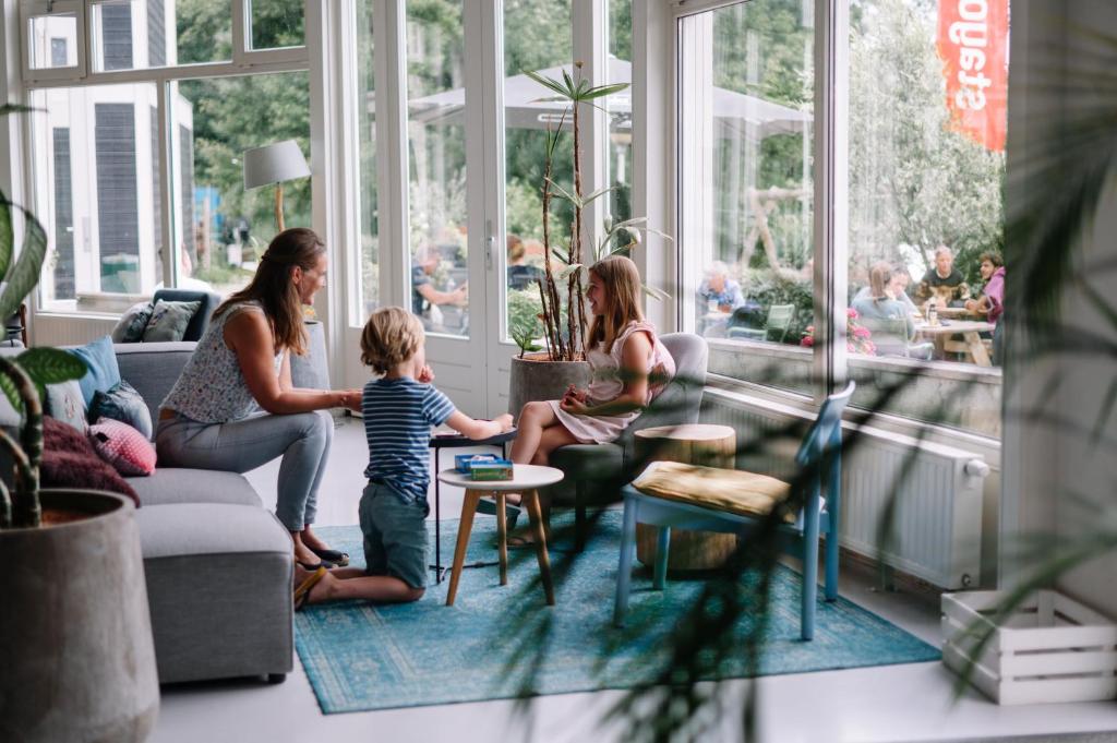 un grupo de personas sentadas en una sala de estar en Stayokay Hostel Dordrecht - Nationaal Park De Biesbosch, en Dordrecht