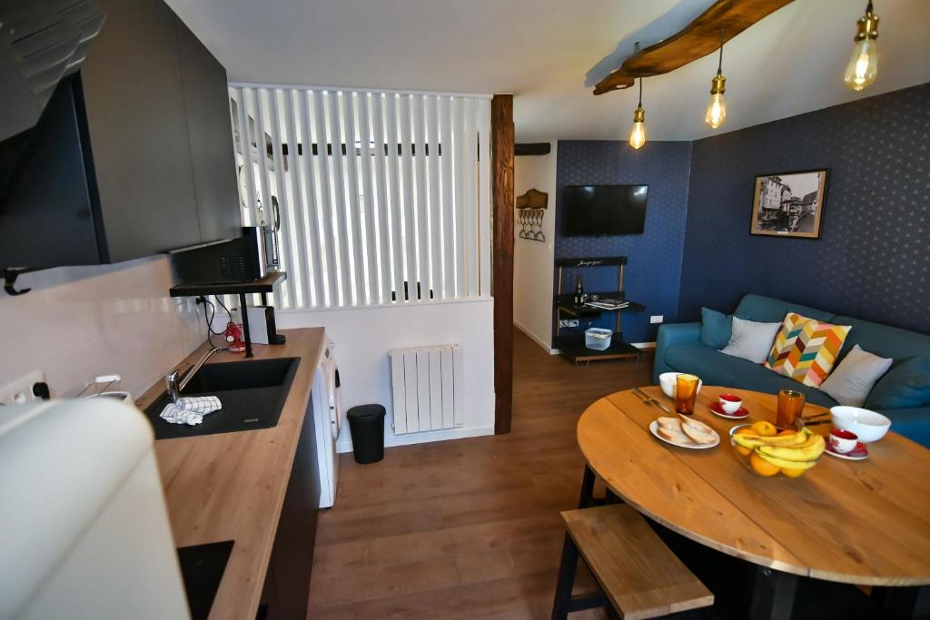 a living room with a table and a blue couch at Au Fil du Temps in Sélestat