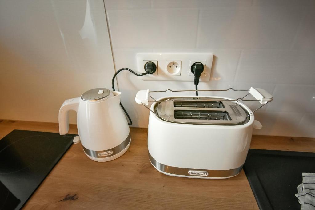 a toaster and a coffee maker on a counter at Au Fil du Temps in Sélestat