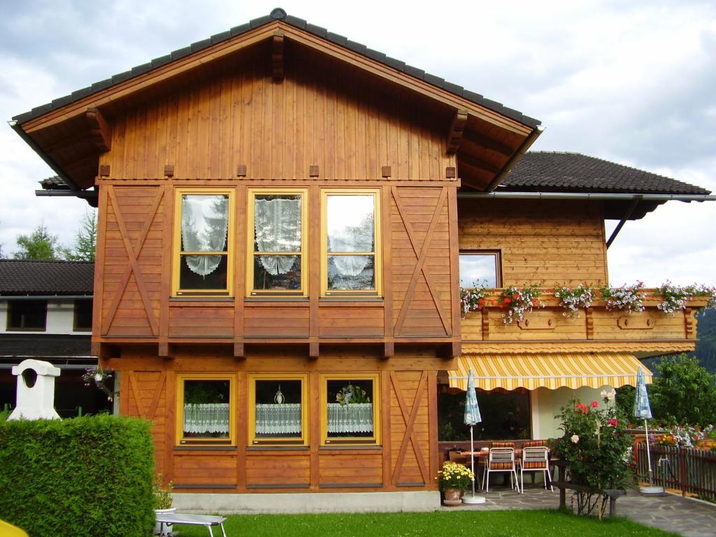 ein Holzhaus mit Fenstern und einer Terrasse in der Unterkunft Gästehaus Moser in Ranten
