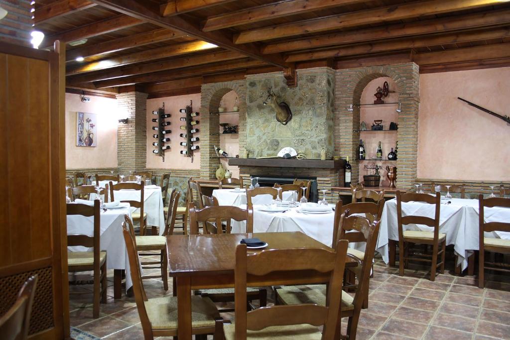 restauracja ze stołami, krzesłami i pianinem w obiekcie Hospedería Los Cahorros w mieście Monachil