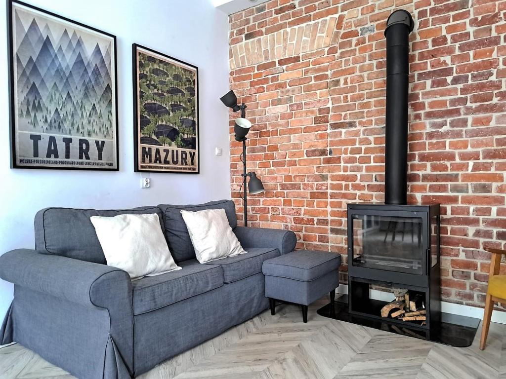 a living room with a couch and a fireplace at Bohema Apartement with private parking in Toruń