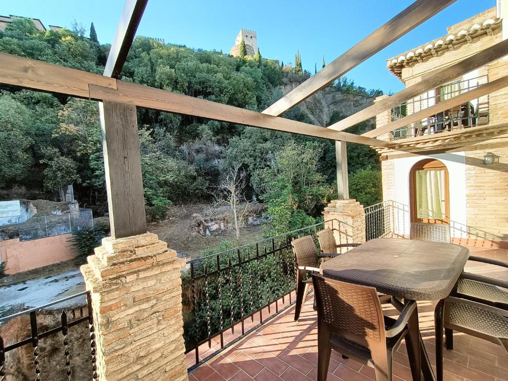 a patio with a table and chairs on a balcony at Casa yamur bajo la Alhambra in Granada
