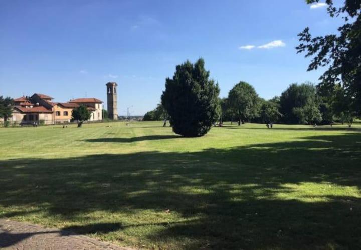 un grand champ verdoyant avec des arbres et un silo dans l'établissement Appartamento vicino ai laghi e Aereoporto di malpensa, à Cassano Magnago