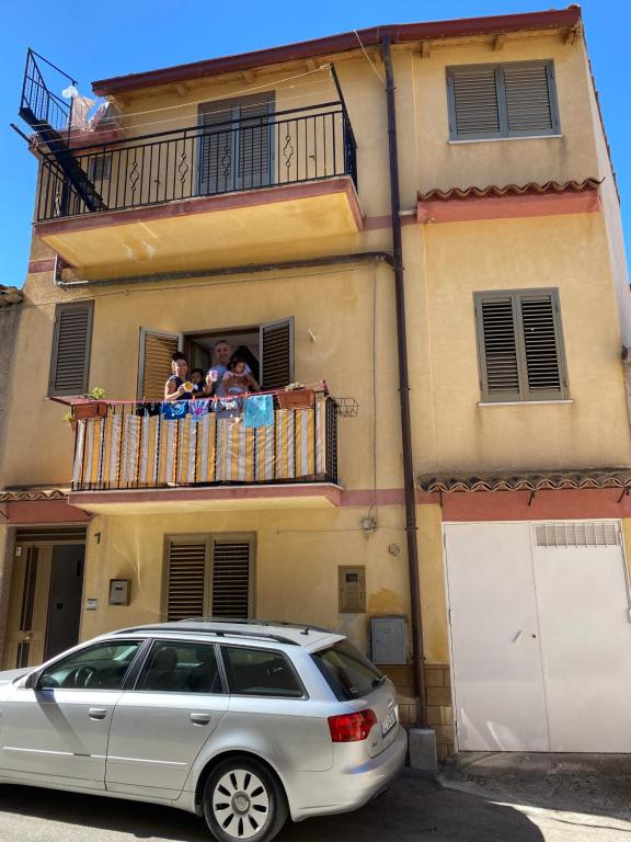 una famiglia che si affaccia su un balcone di una casa di Casa Fontanelle a Burgio
