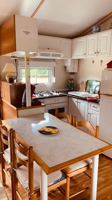 une cuisine avec une table et des chaises dans une cuisine dans l'établissement Petite maison dans la prairie, à Cabanac-et-Villagrains