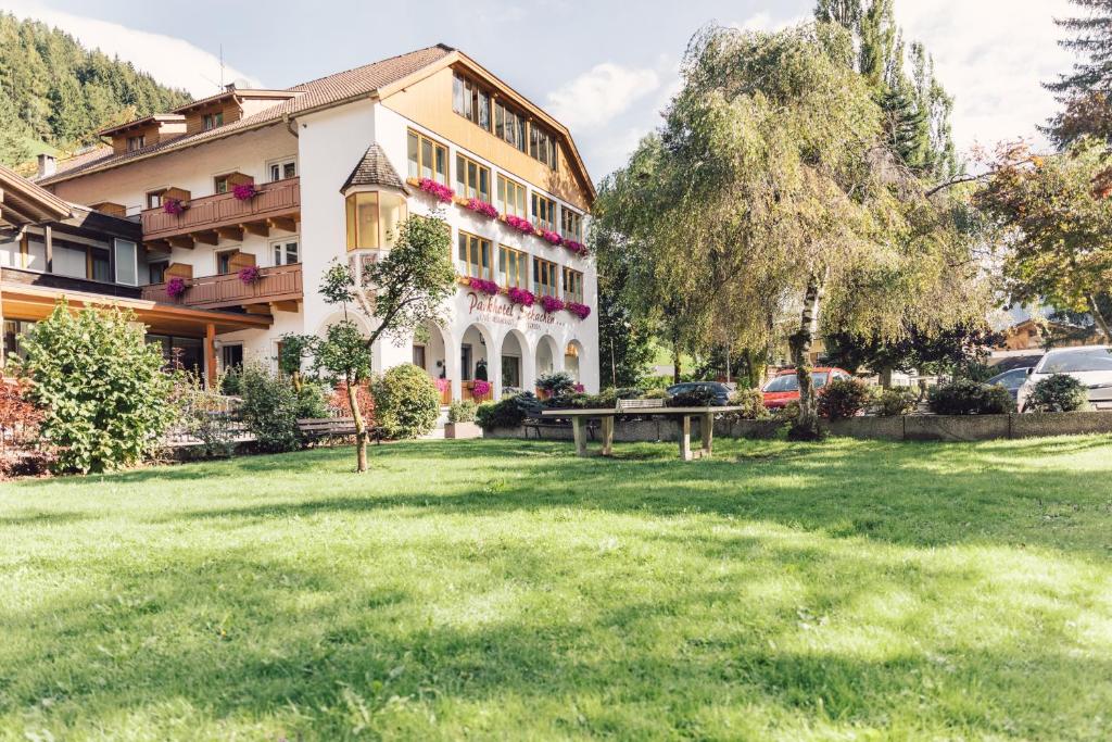 ein großes Gebäude mit einem Park davor in der Unterkunft Parkhotel Schachen in St. Johann im Ahrntal