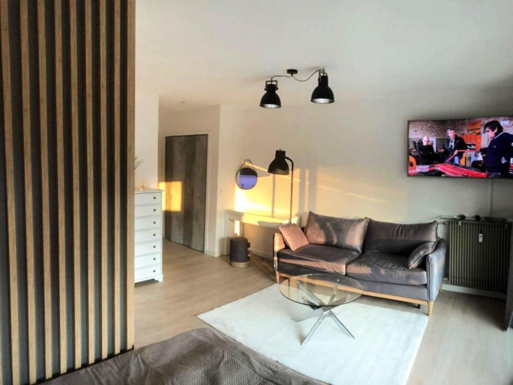 salon z kanapą i szklanym stołem w obiekcie Cozy studio apartment in Cannes - AC-Self check-in w Cannes