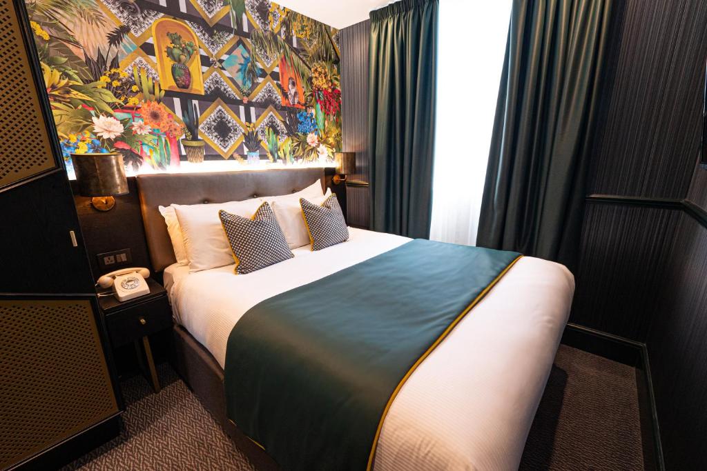 um quarto de hotel com uma cama e uma parede colorida em Hyde Park Green em Londres