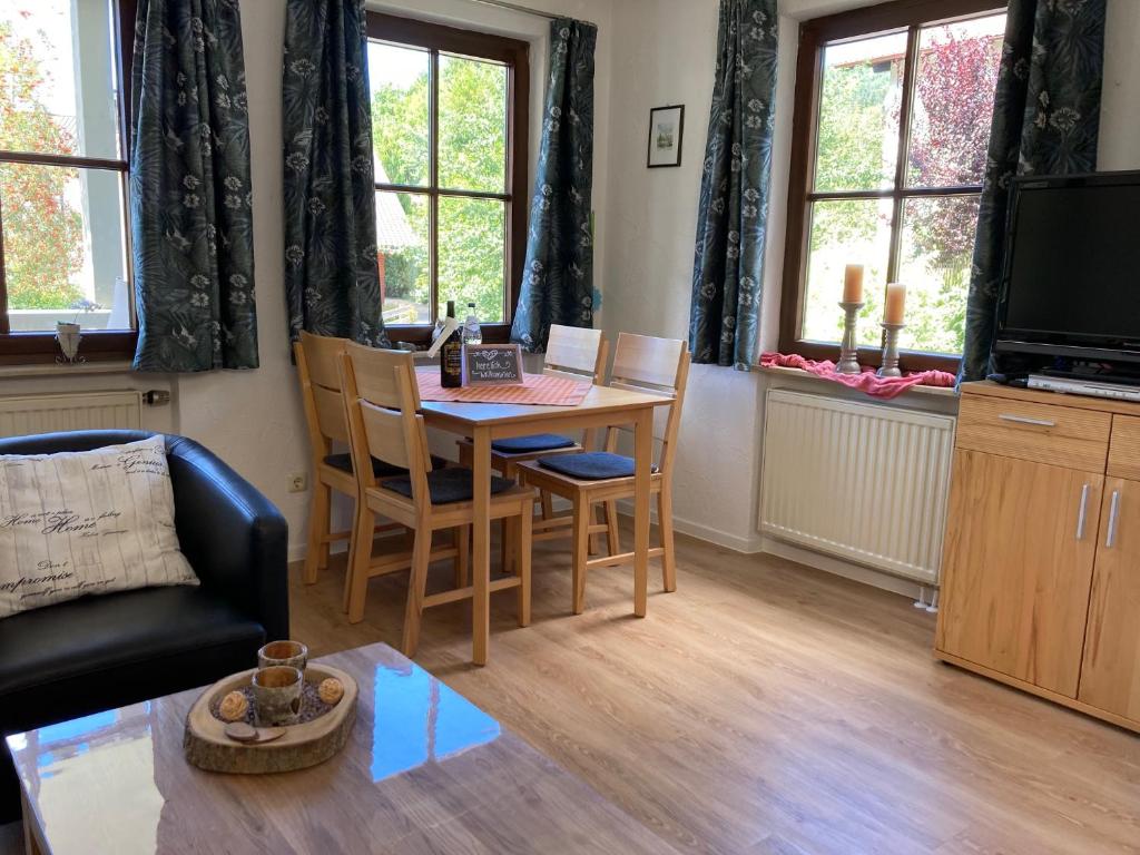 a living room with a table and chairs and a television at Ferienwohnung Allgäublick Regina in Bad Hindelang