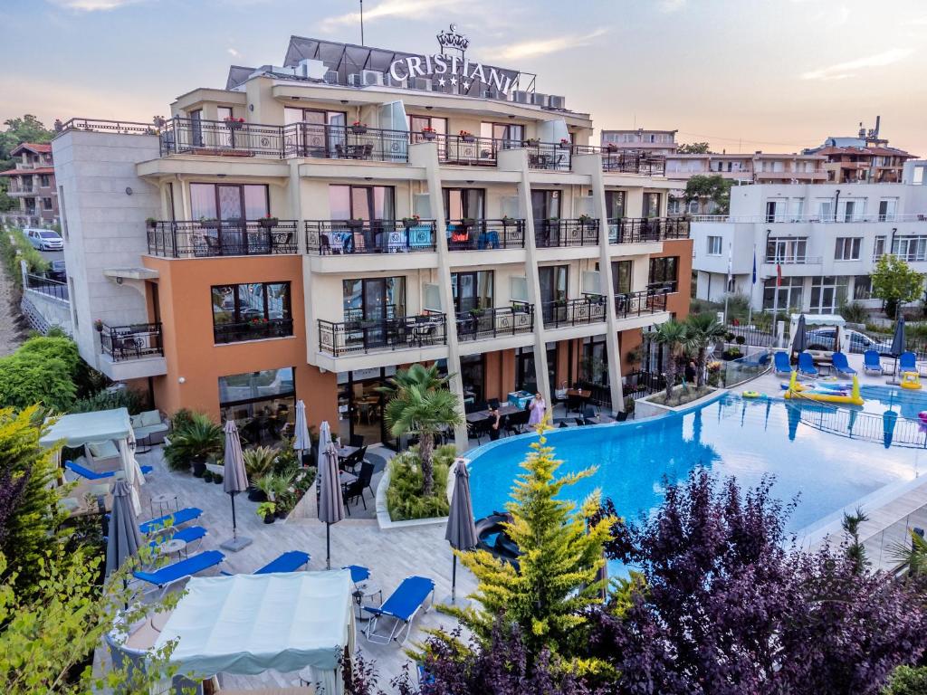 a hotel with a swimming pool in front of a building at Cristiani Hotel Sozopol in Sozopol