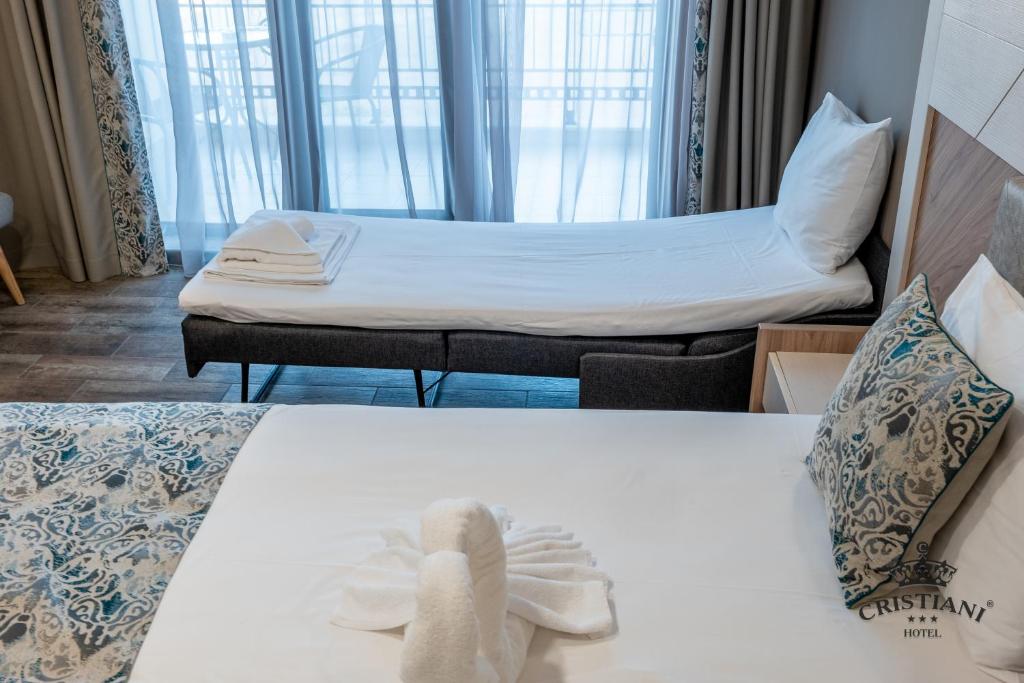 A bed or beds in a room at Cristiani Hotel Sozopol