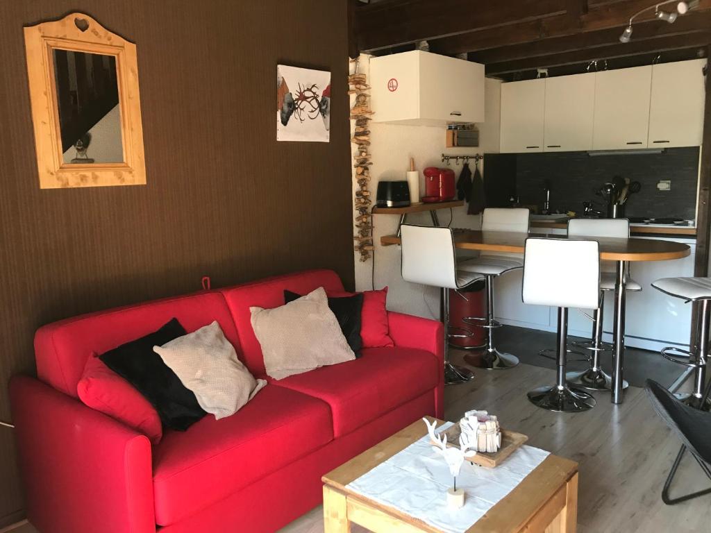 a living room with a red couch and a table at Coup de coeur - Centre station, Proche pistes de ski in Les Deux Alpes