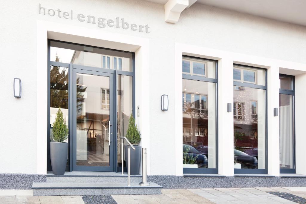 een wit gebouw met een deur naar een hotel energeticist bij Hotel Engelbert in Iserlohn