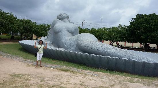 a woman standing in front of a large statue at Hotel Sunday - Townhouse Club Airport Trivandrum in Trivandrum