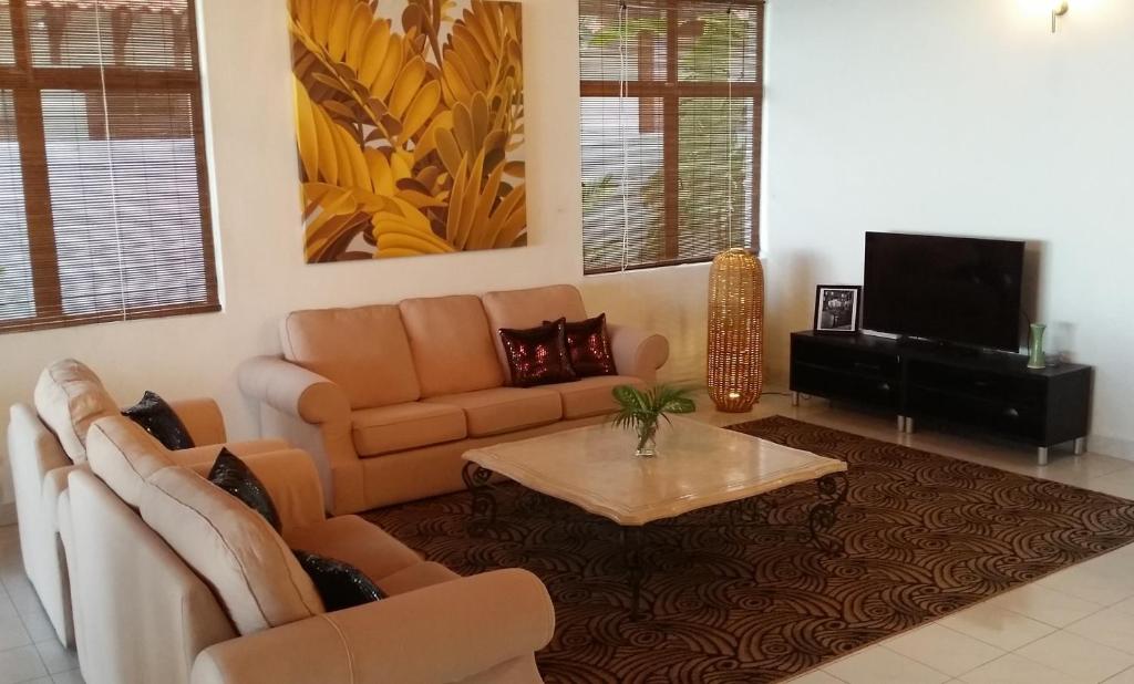 ein Wohnzimmer mit einem Sofa und einem Couchtisch in der Unterkunft Beach Front Bungalow Tanjung Bungah in George Town