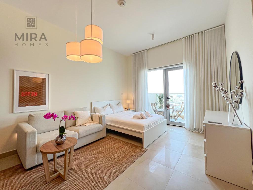 a living room with a couch and a table at Mira Holiday Homes - Serviced studio with balcony in Dubai