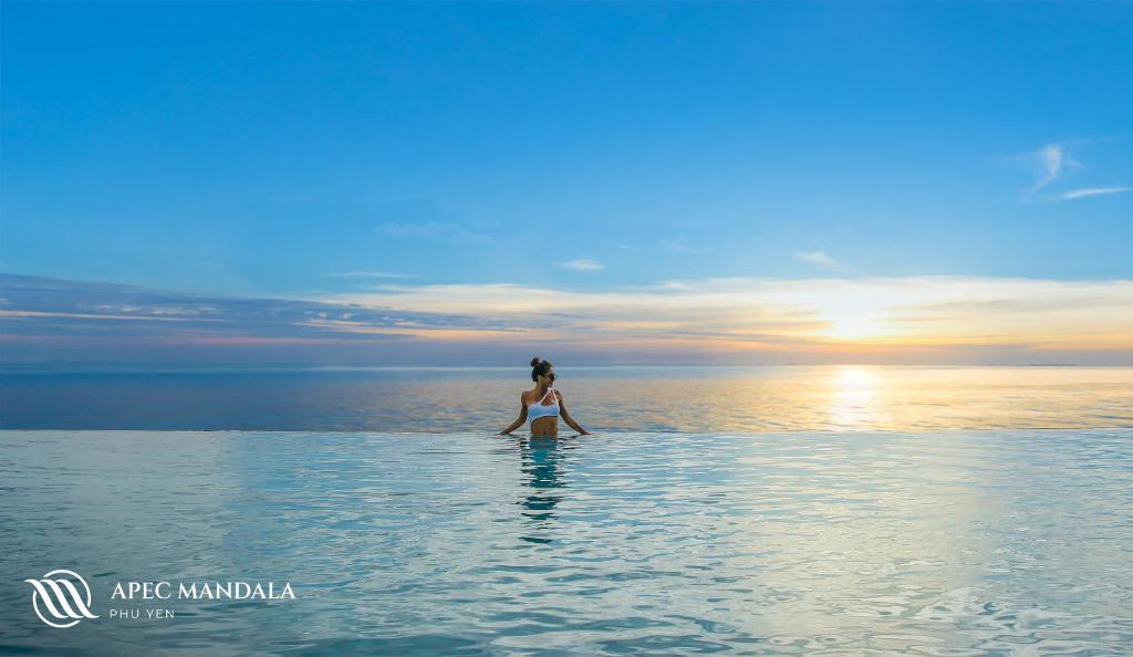 Mandala Hotel & Spa Phú Yên في توي هوا: امرأة تقف في الماء في المحيط