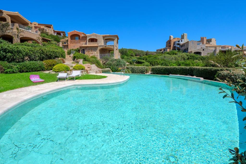 una grande piscina in un cortile con case di Villetta Azzurro - SHERDENIA Luxury Apartments a Marinella
