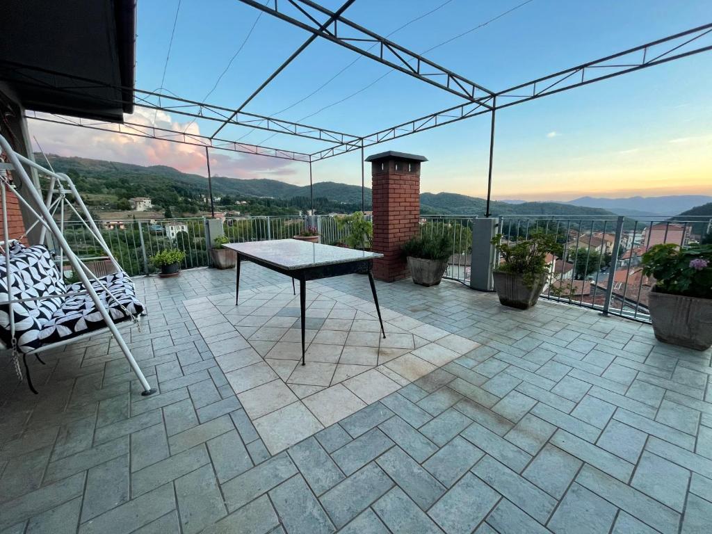 a patio with a table and chairs on a balcony at Tuscany Hills Penthouse in Fivizzano