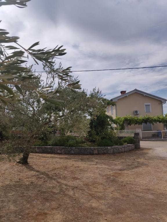 a house with a tree in front of a yard at Apartment Nenadic in Hrahorić
