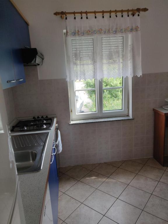 a kitchen with a stove and a window in it at Apartment Nenadic in Hrahorić