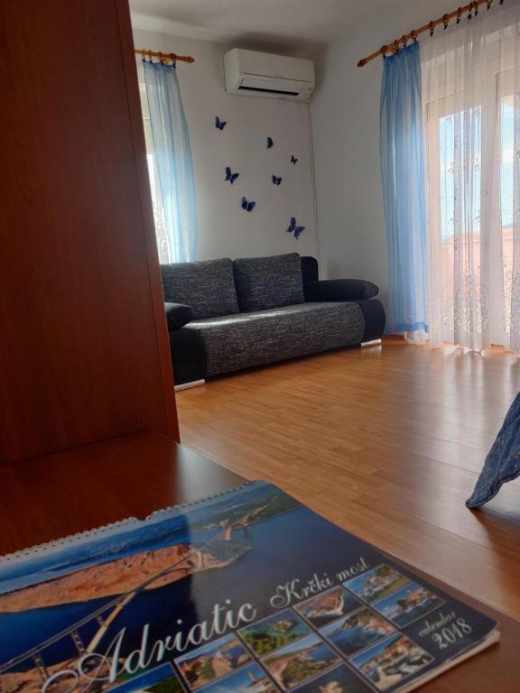 a living room with a couch and a wooden floor at Apartment Nenadic in Hrahorić