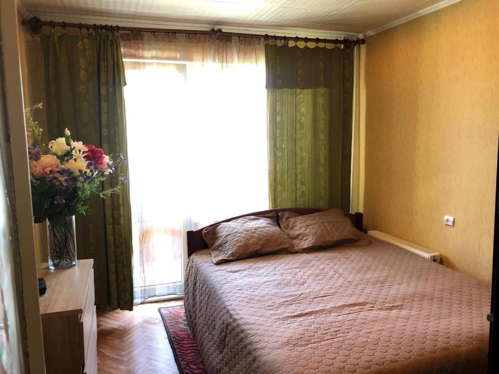 a bedroom with a bed in front of a window at KULDIGAS 38 APARTMENTS in Liepāja